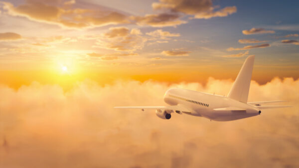 Passengers commercial airplane flying above clouds in sunset light. 3D rendering illustration.